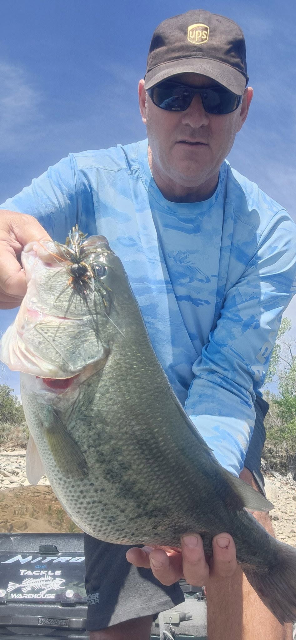 A Colorado angler holding a 5 pound bass caught on a Bass Binge jig